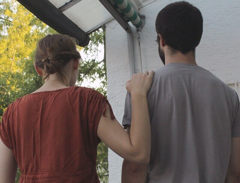 Une femme met sa main sur l’épaule d’un homme